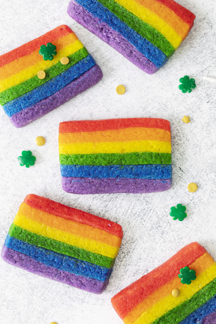 close up photo of st. patricks day cookies (a rainbow cookie recipe) surrounded by gold sprinkles and shamrock sprinkles