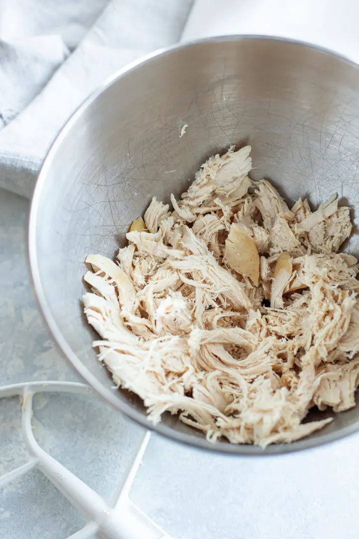 photo of a stand mixer bowl with shredded chicken in it 