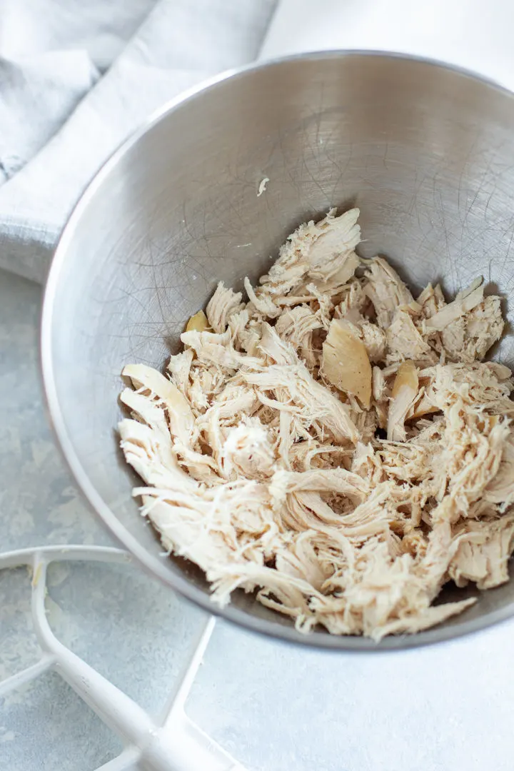 photo of a stand mixer bowl with shredded chicken in it