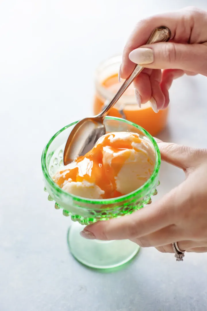 photo of a woman eating this grapefruit curd recipe on a bowl of ice cream