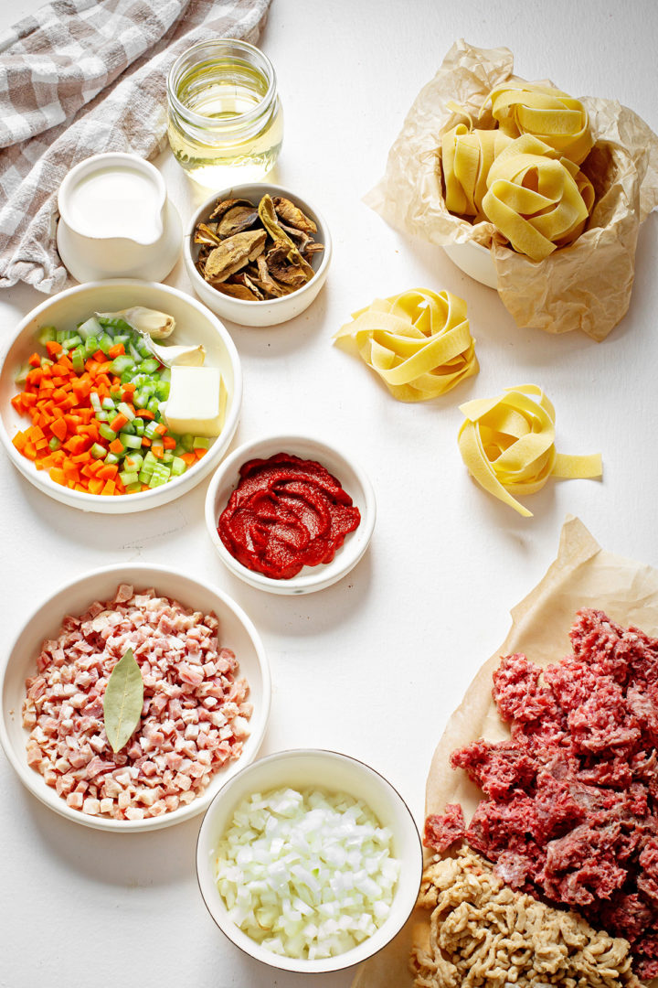 easy bolognese sauce ingredients on a white surface