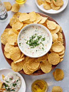 overhead photo of queso blanco in a white bowl with chips and beer