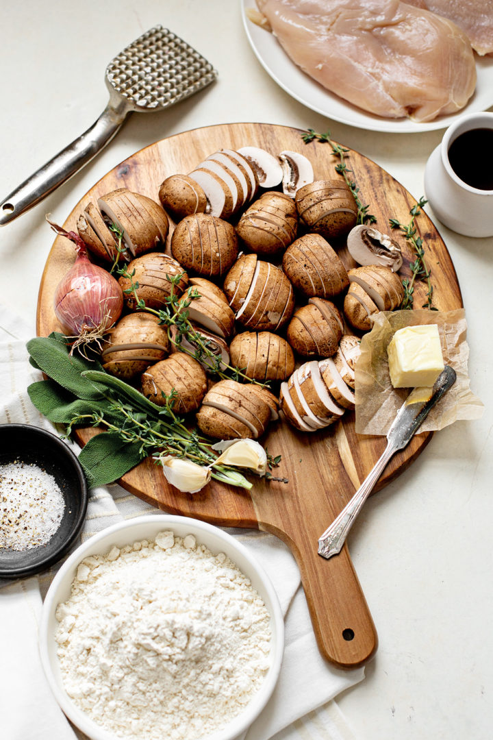 ingredients for this recipe for chicken marsala arranged on a wooden cutting board