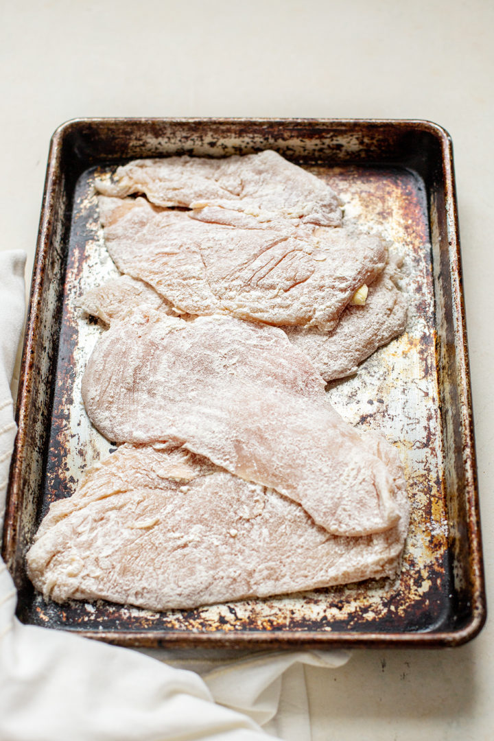 photo showing how to dredge chicken in flour to make a recipe for chicken marsala
