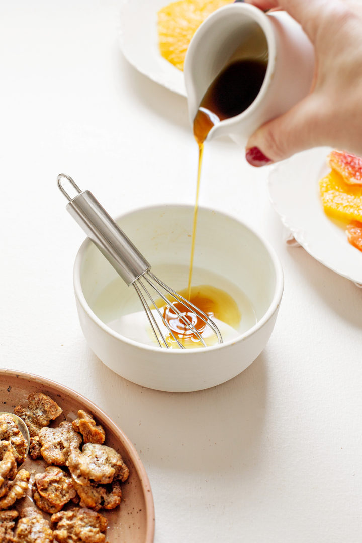 woman making poppy seed dressing for a citrus salad