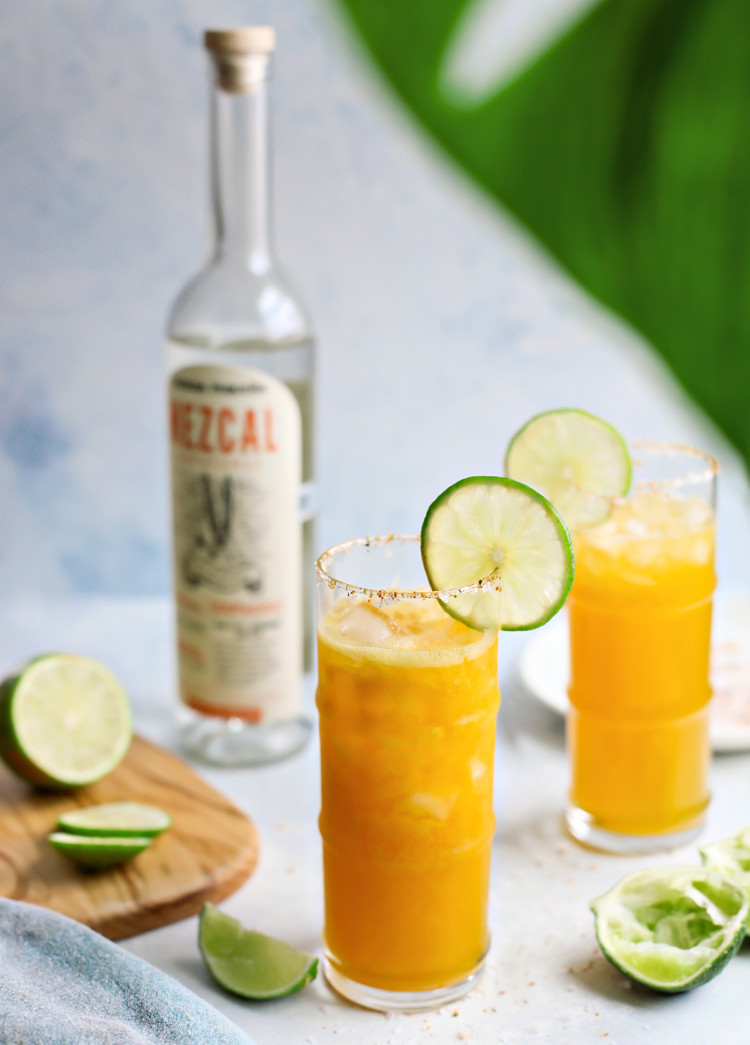 photo of two passionfruit margaritas next to a bottle of mezcal