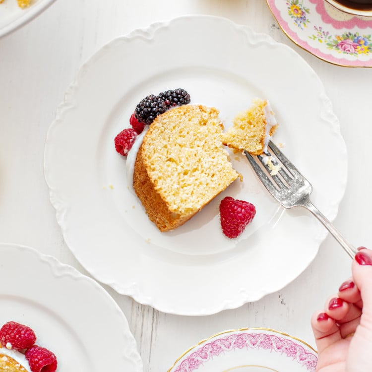 a slice of lemon ricotta cake on a white plate with fresh berries