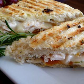 photo of two slices of a roasted chicken sandwich made with focaccia and brie