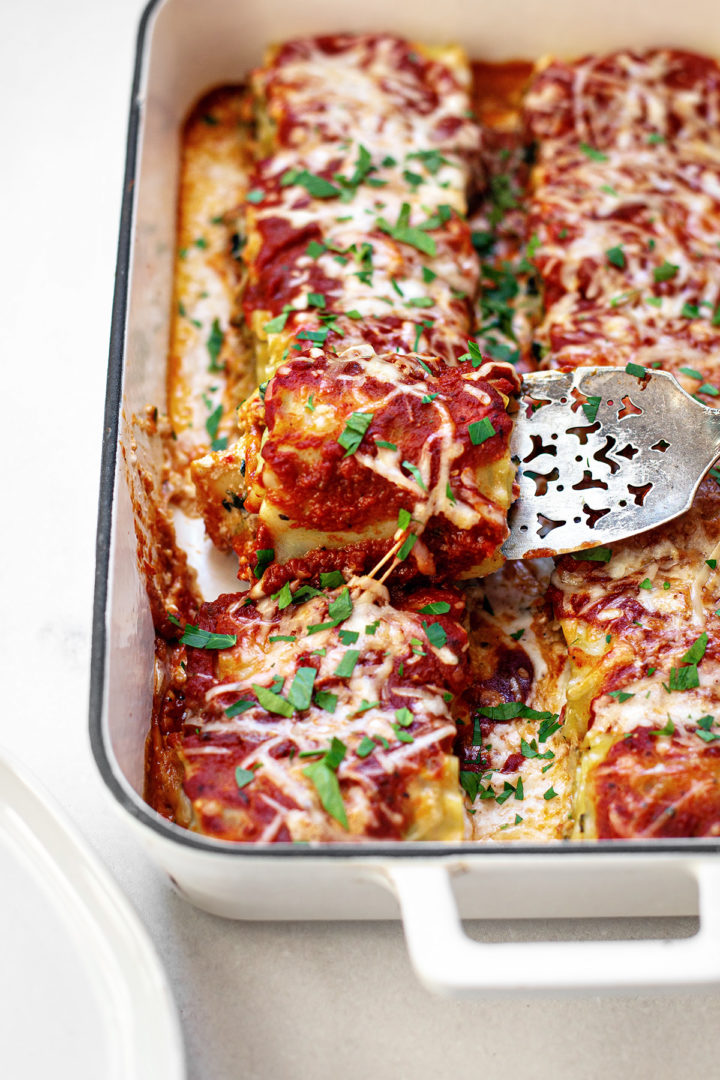 serving a pan of spinach lasagna rolls