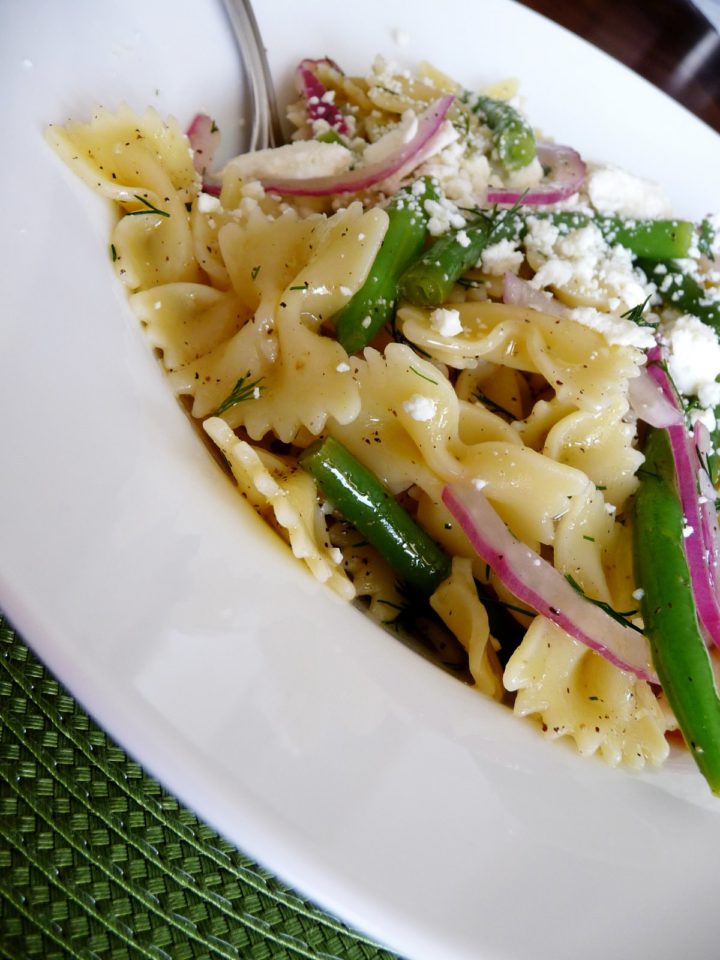 close up photo of a white bowl of green bean pasta, an easy summer pasta salad