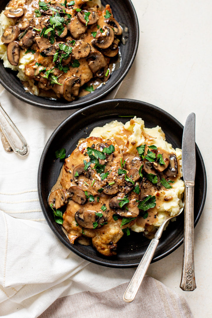 two black dishes set on a table plated with the best chicken marsala recipe