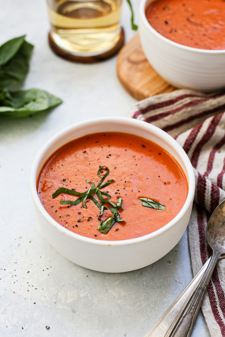 photo of a recipe for homemade tomato soup served in white soup bowls