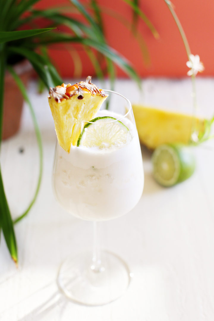 glass of shaken pina colada on a white table