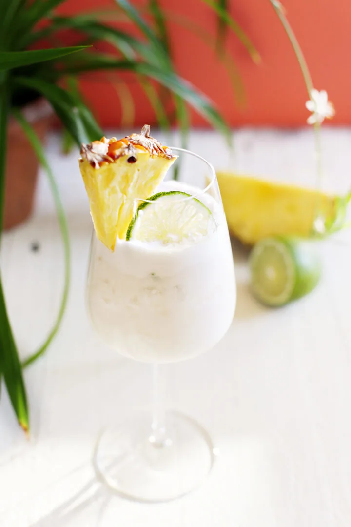 glass of shaken pina colada on a white table