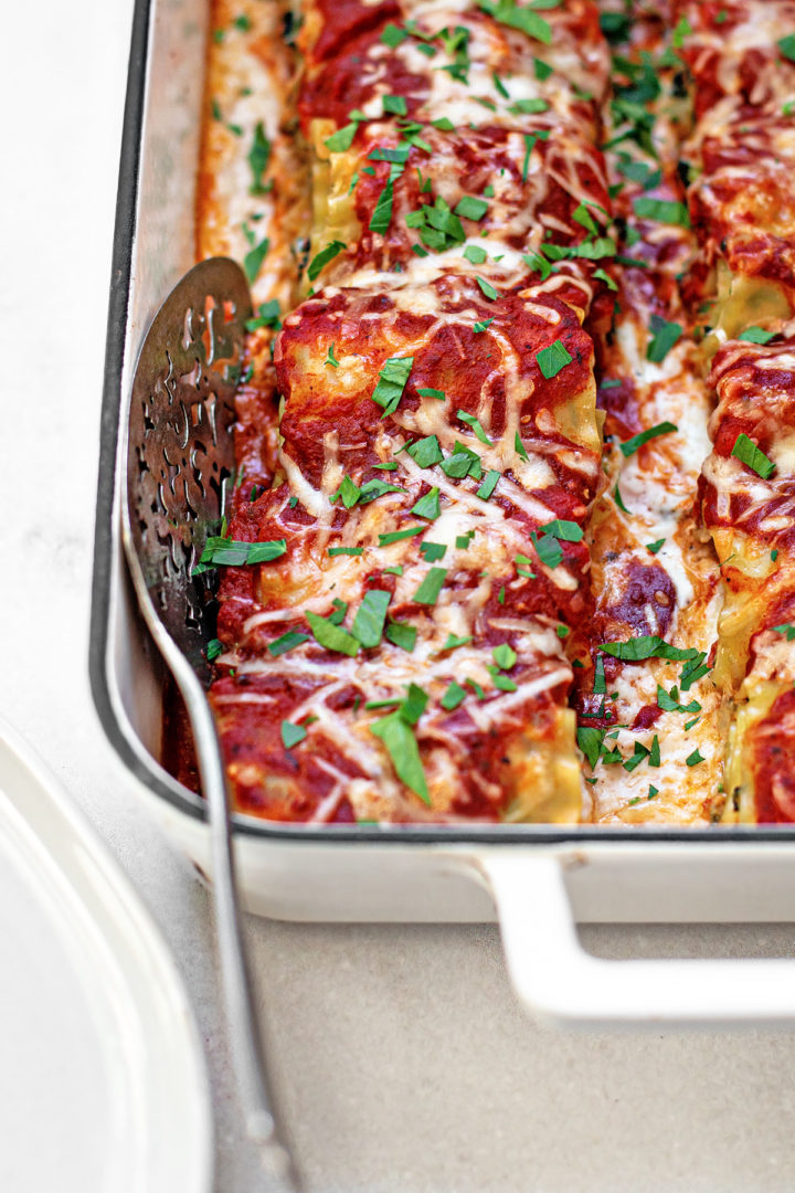 a pan of baked lasagna roll ups recipe with spinach