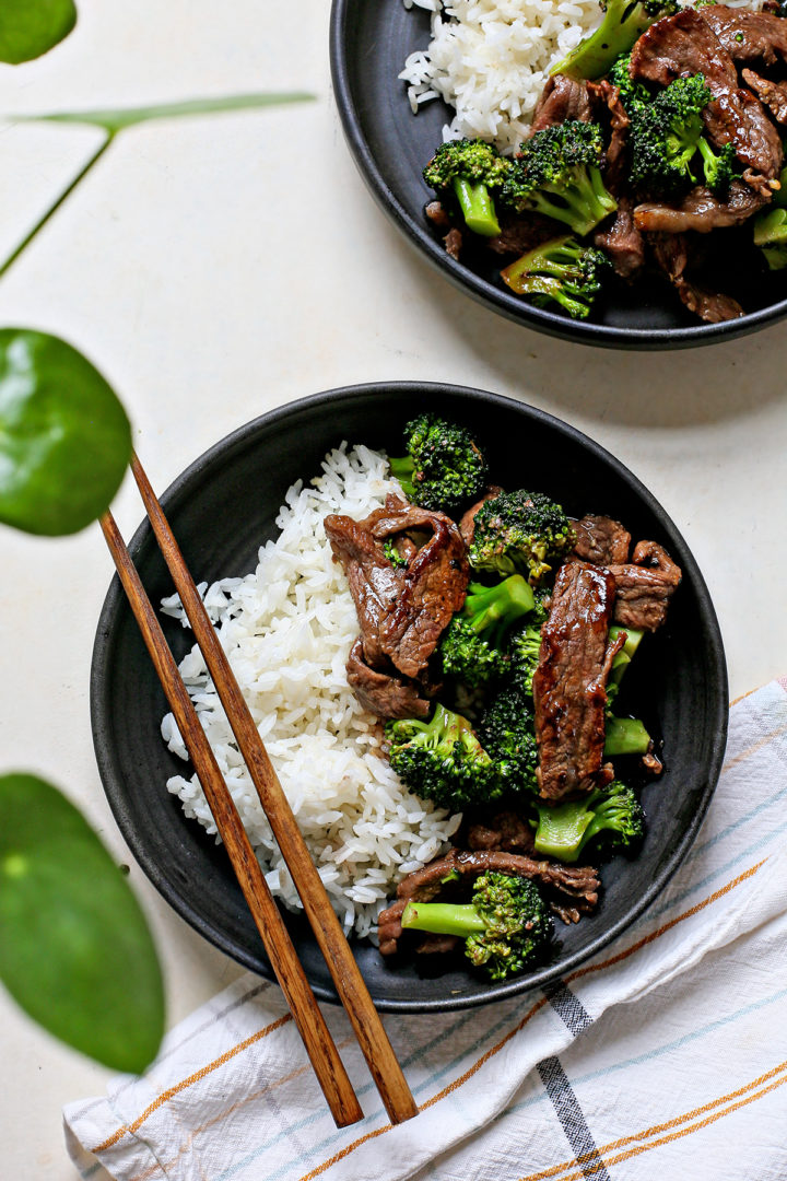 photo of chinese beef and broccoli in two black plates served with rice