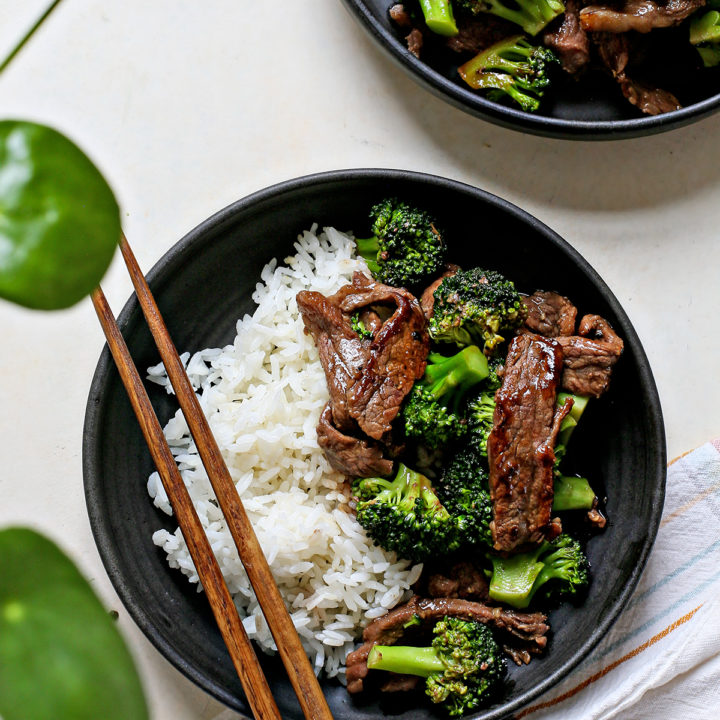 overhead photo of Chinese beef and broccoli being served on two black plates