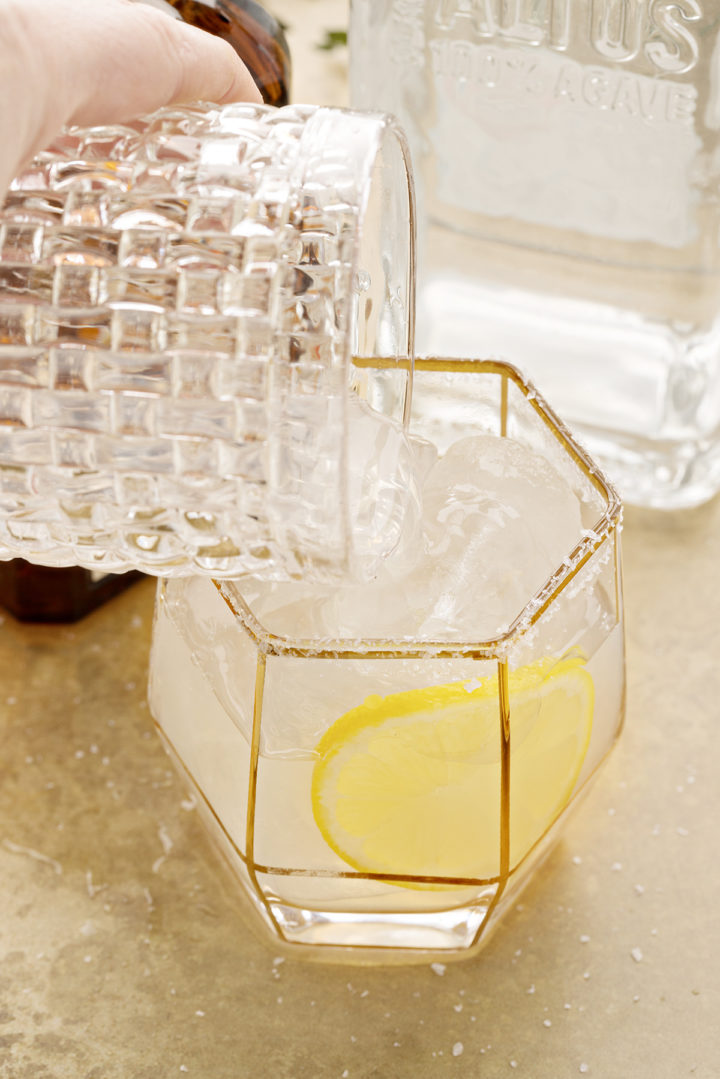 photo of a lemon tequila cocktail being poured into a salt rimmed glass