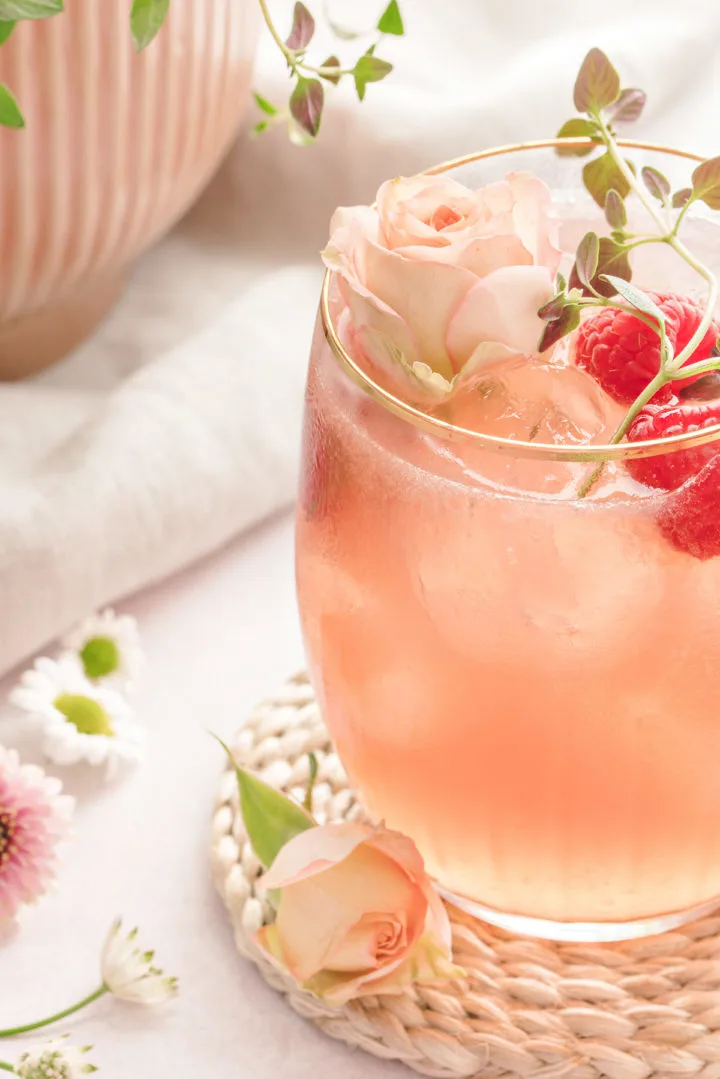 a glass of cocktail floradora next to fresh flowers