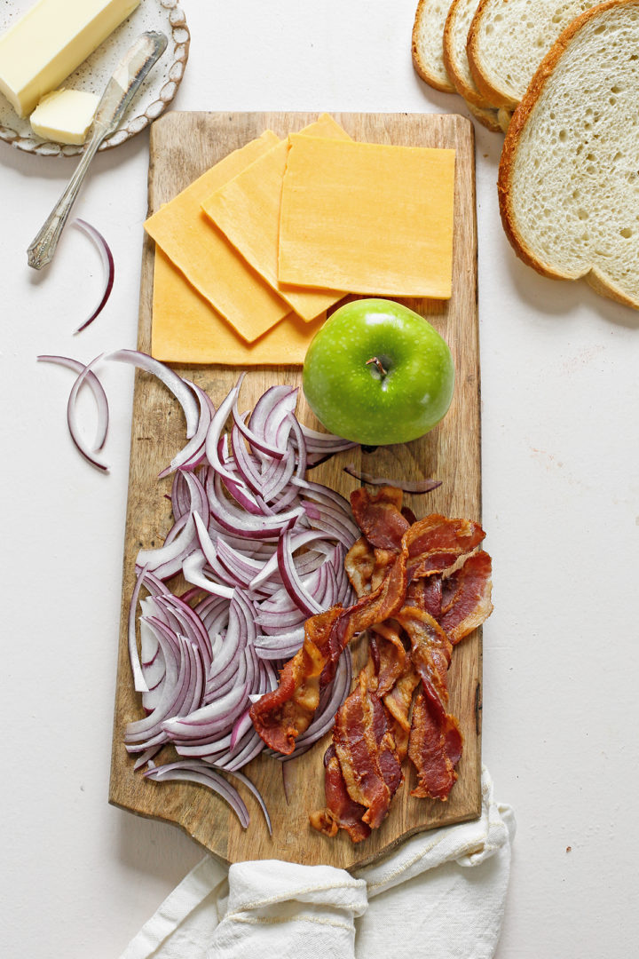 ingredients in this apple and bacon grilled cheese sandwich arranged on a cutting board