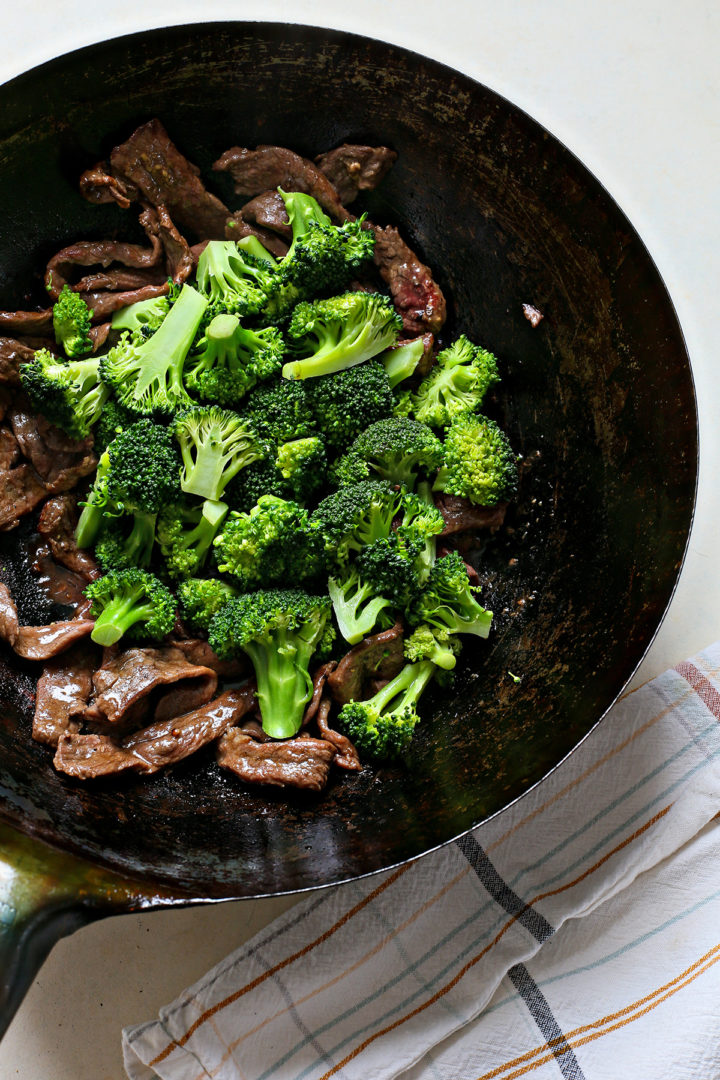 combining the cooked broccoli with the flank steak to make chinese beef and broccoli