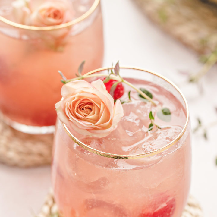 photo of two glasses of a floradora cocktail with fresh raspberries