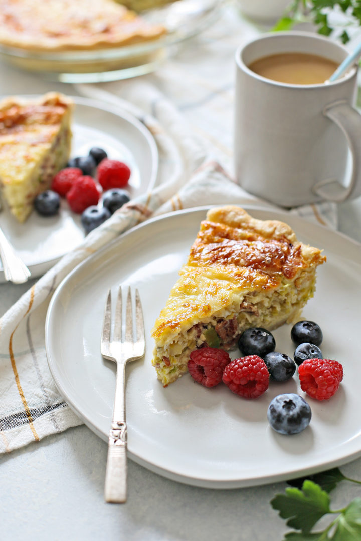 brunch table set with two servings of this easy quiche lorraine recipe, served with fresh berries