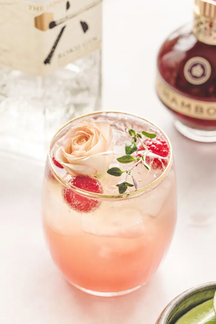 photo of a prepared floradora (a drink  made with gin and ginger beer) next to a bottle of chambord and gin