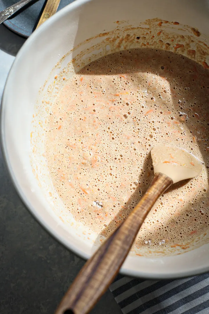 prepared carrot pancake batter in a bowl with a spatula to stir