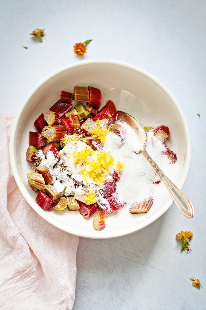 rhubarb in a bowl with sugar and lemon zest for a rhubarb cake recipe