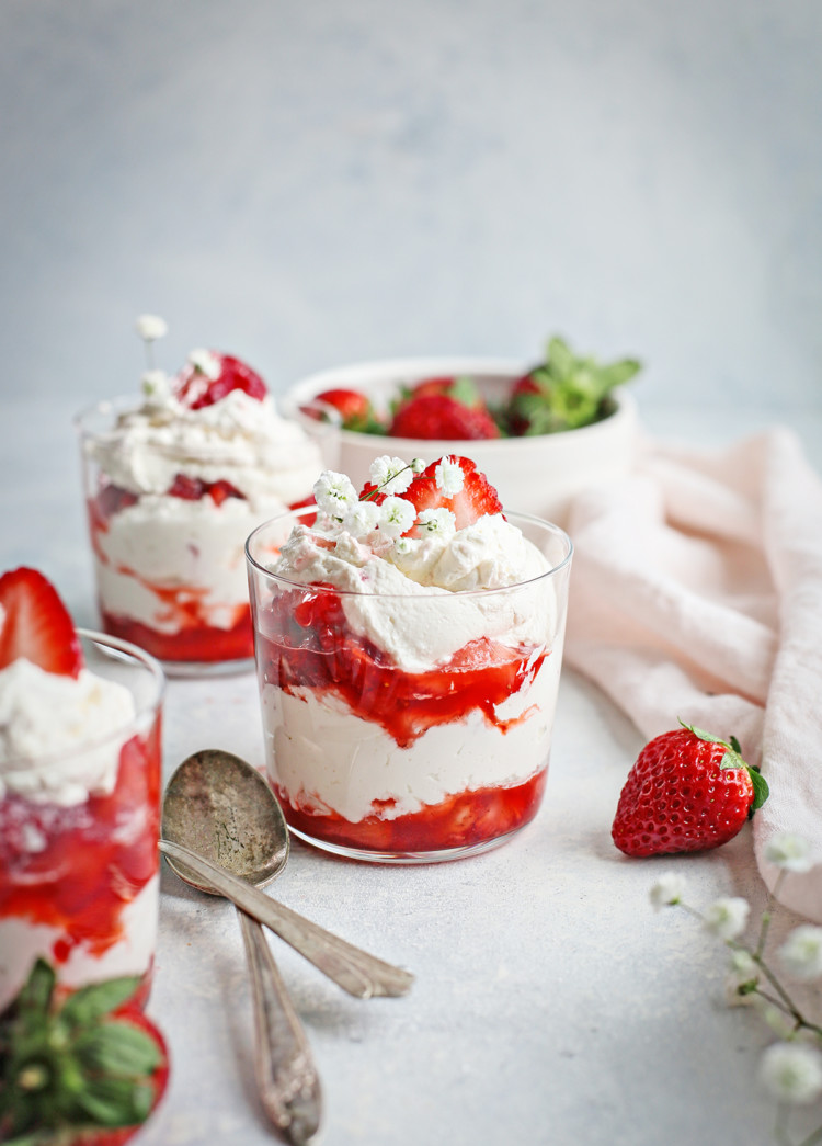 strawberries and cream served in three clear dessert dishes