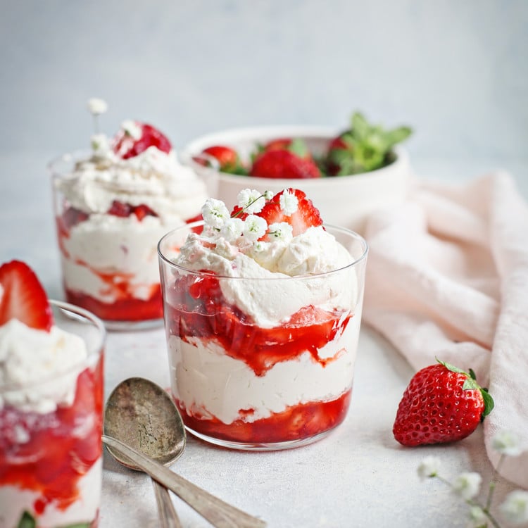 strawberries and cream served in three clear dessert dishes