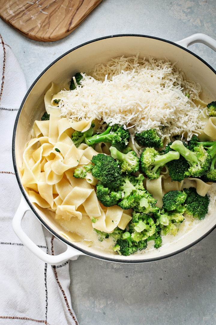 adding parmesan to alfredo sauce