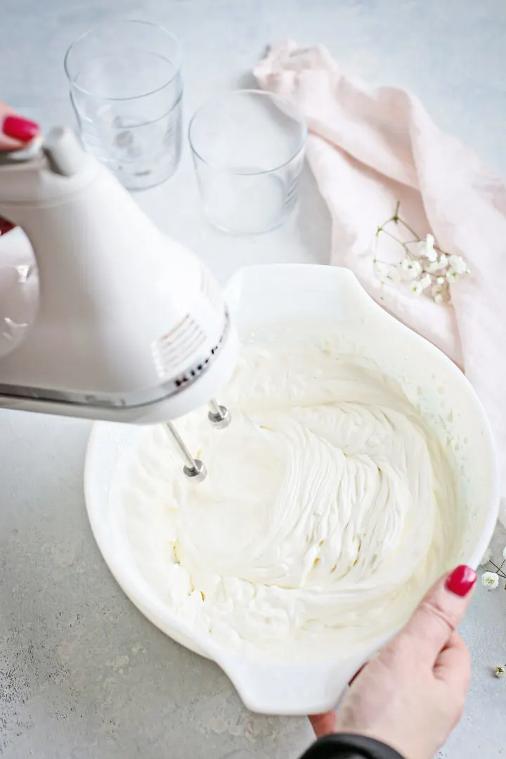 woman making whipped cream to make strawberry fool (a strawberries cream recipe)