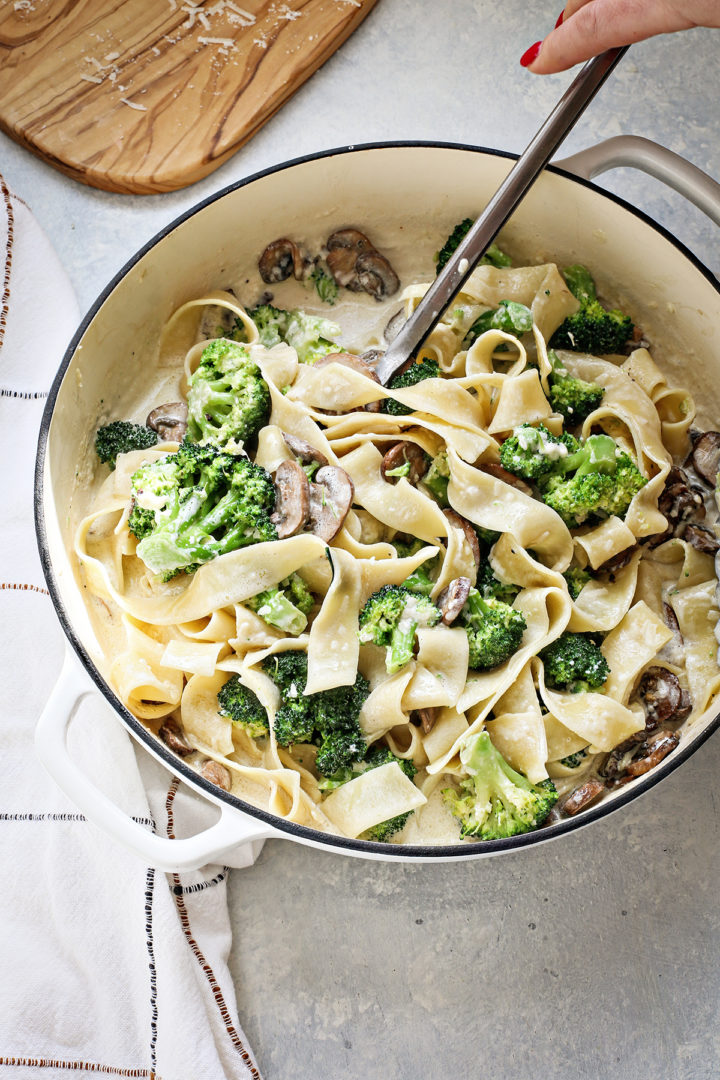 woman stirring a pot of mushroom alfredo pasta