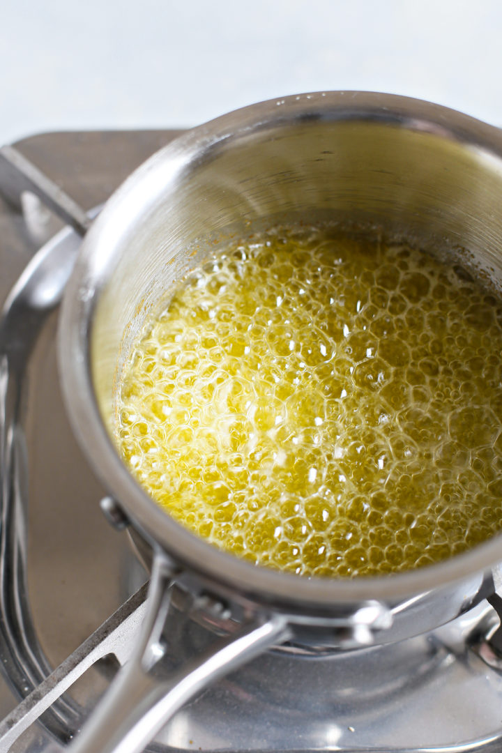 step 4 showing how to make brown butter - melted butter cooking in a saucepan