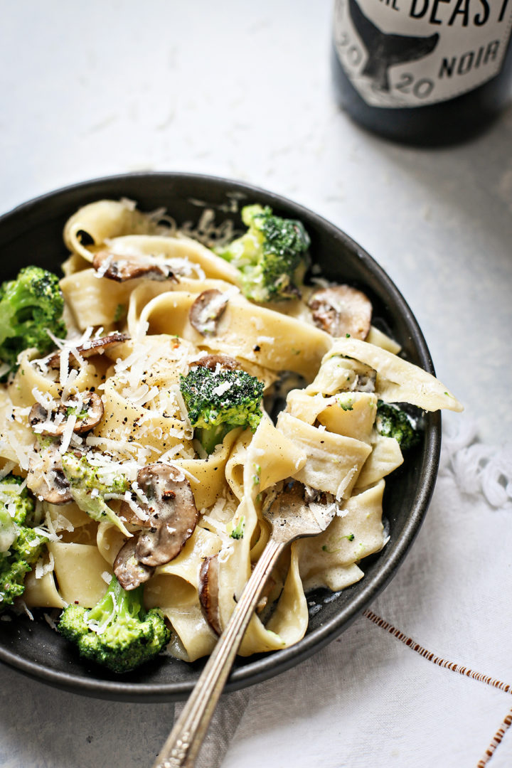 close up photo of a bowl of mushroom fettuccine alfredo with a fork