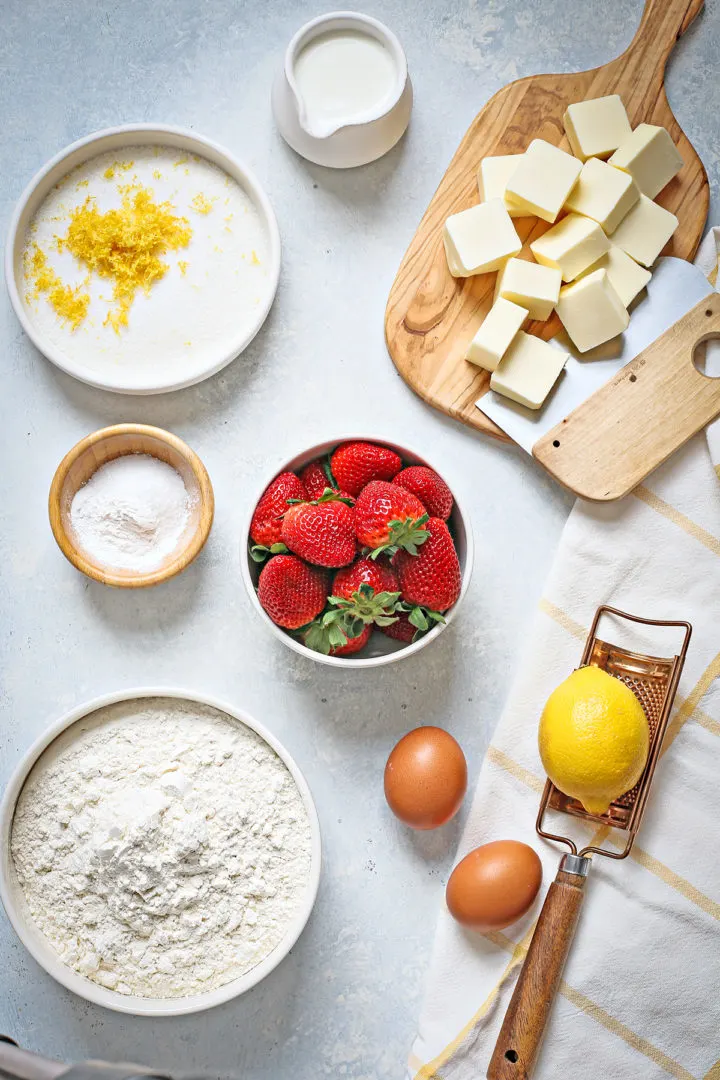 photo of ingredients needed to make strawberry scone recipes arranged on a blue table