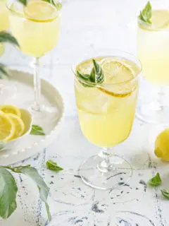 photo of 3 glasses of limoncello spritz on a white and blue tile background