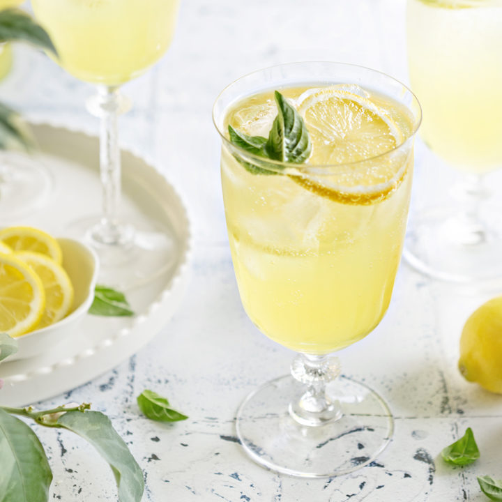 photo of 3 glasses of limoncello spritz on a white and blue tile background