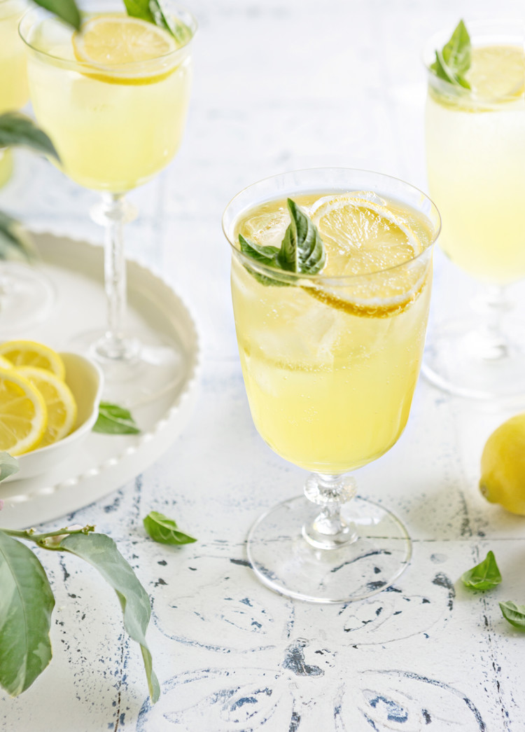 photo of 3 glasses of limoncello spritz on a white and blue tile background