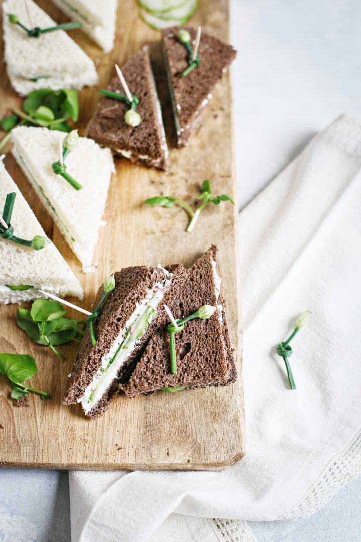 wooden cutting board with watercress sandwiches