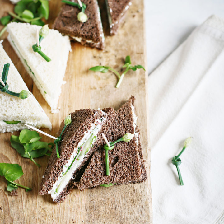 watercress sandwiches on a wooden cutting board