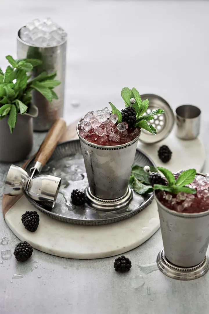 two glasses of derby day cocktail ready to serve (blackberry bourbon mint juleps)