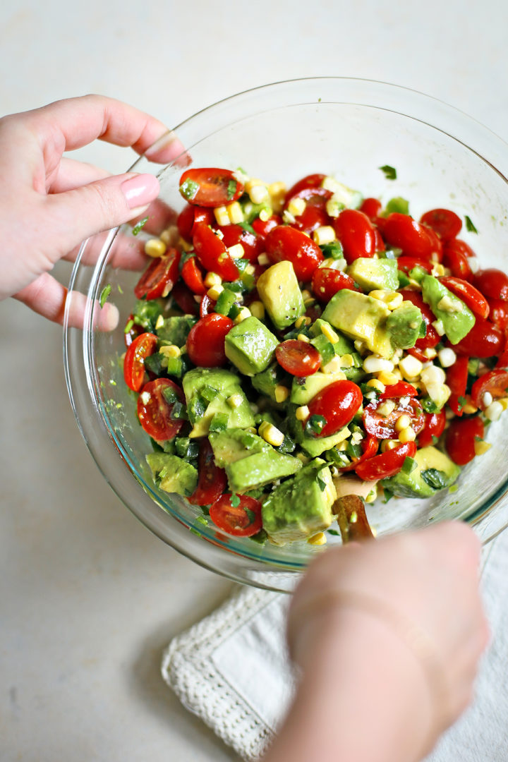 step 4 woman stirring tomato avocado corn salad