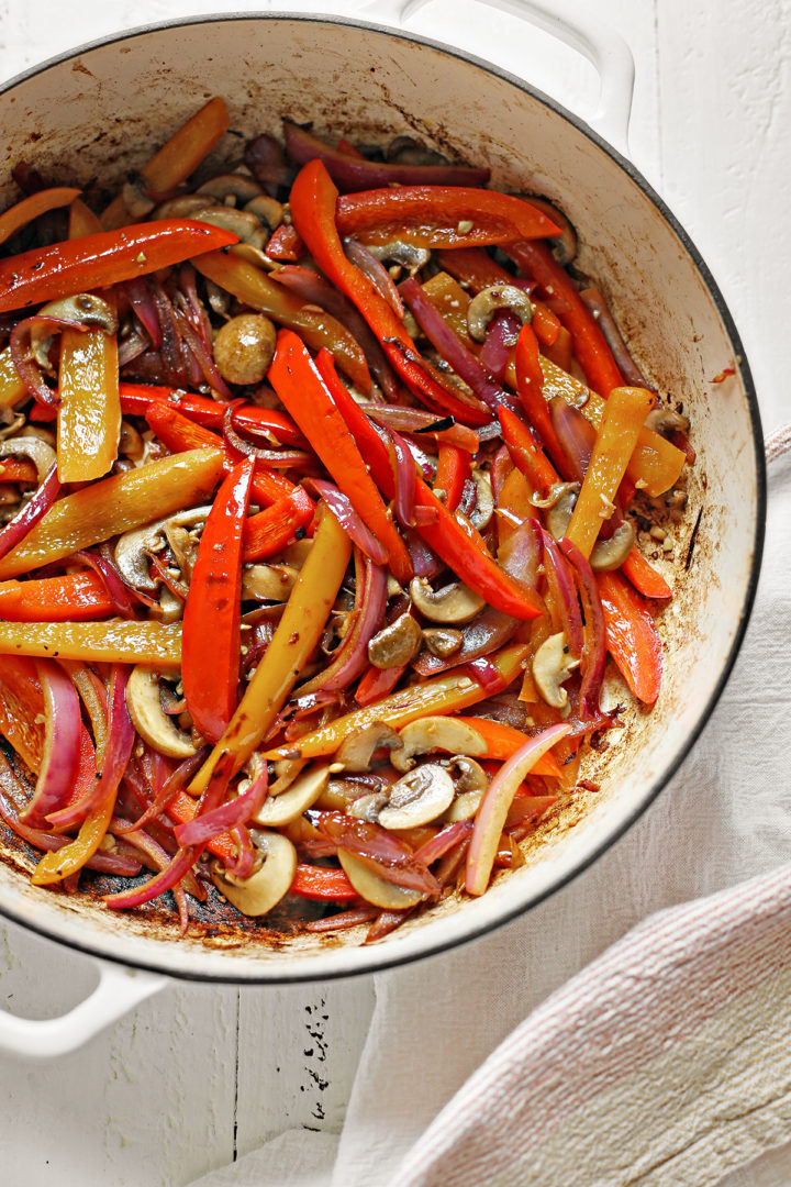 bell peppers, onions, and mushrooms cooking for veggie fajitas