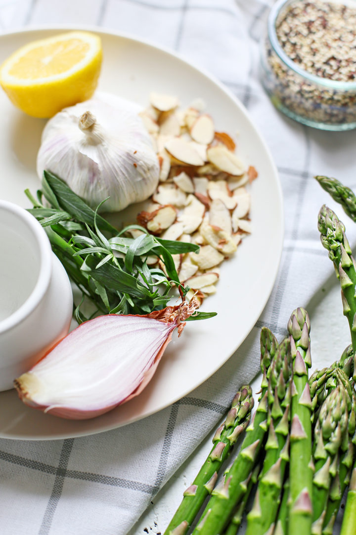 photo of fresh tarragon and other ingredients in this recipe for asparagus salad on a white plate