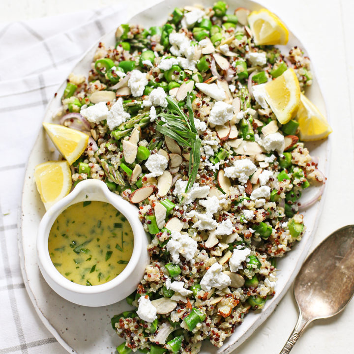 cold asparagus salad with goat cheese on a white platter