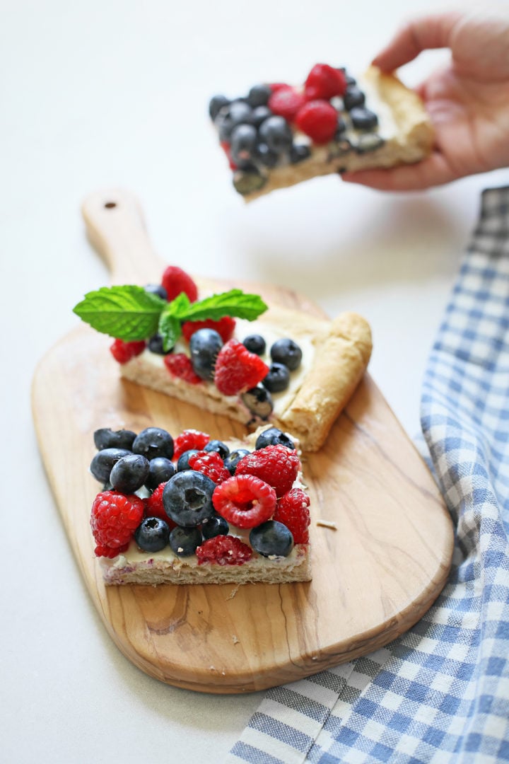 woman picking up a slice of these red, white, and blue dessert bites to eat