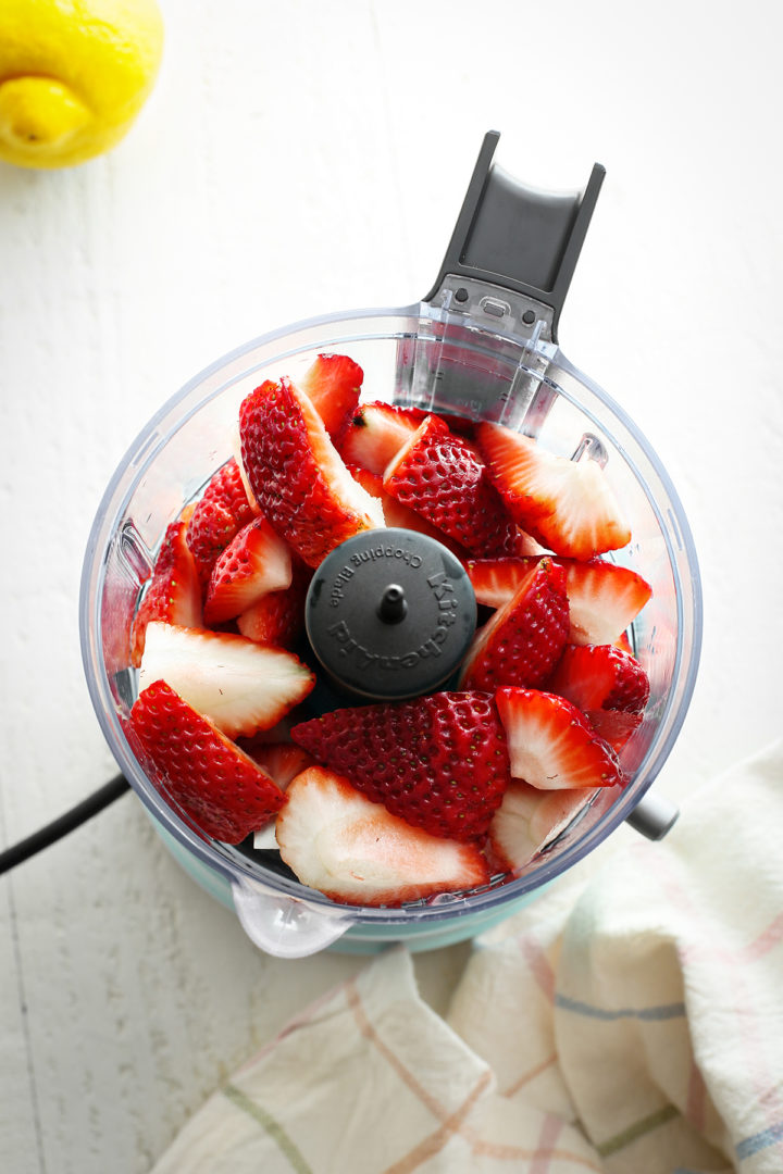 fresh strawberries in a food processor showing step 1 for how to make strawberry topping